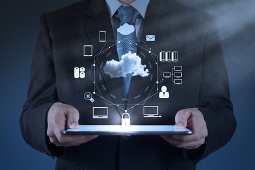 Man in a suit holding a laptop with different business communication symbols floating around