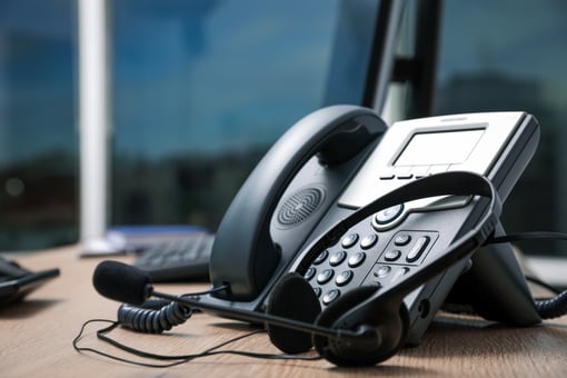 Stationary phone and headset on office desk